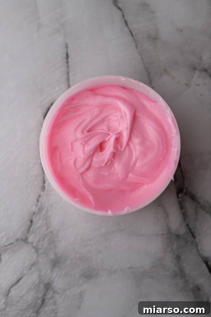 Valentines Sweetheart Cinnamon Buns Made Easy 9 A bowl of white icing, now perfectly mixed with pink food coloring, ready to be spread over the freshly baked cinnamon rolls.