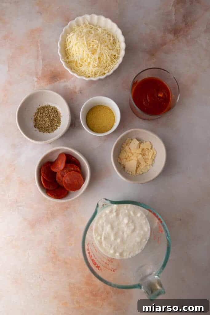 Essential ingredients for a delicious and healthy cottage cheese pizza bowl dip recipe laid out neatly.