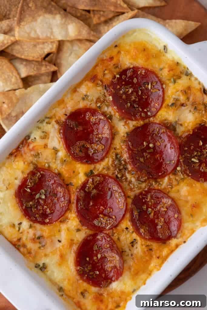 Overhead shot of a delicious and fully cooked cottage cheese pizza bowl dip, showcasing its golden, bubbly cheese and crispy pepperoni.