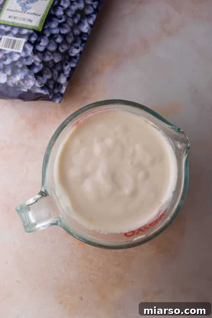 Protein Packed Cottage Cheese Freezer Bark 6 The blended cottage cheese and maple syrup mixture in a blender cup, showing a smooth and creamy texture.