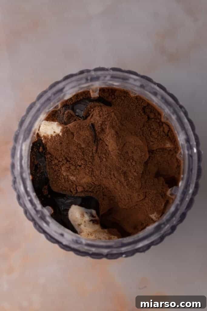 Unmixed chocolate milkshake ingredients in a blender cup before blending.