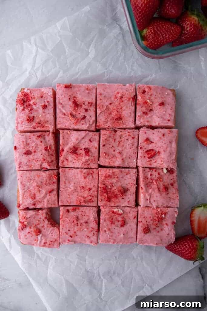 Irresistibly Easy Strawberry Brownies from a Cake Mix 12 A tray of perfectly cut strawberry brownies, showing off their uniform squares and pink glaze.