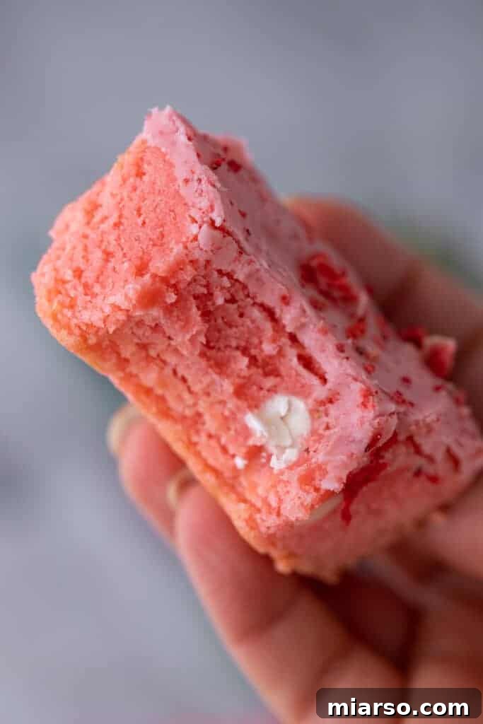 Irresistibly Easy Strawberry Brownies from a Cake Mix 13 Close-up of a delicious strawberry brownie with a corner bitten off, highlighting its perfect texture and glaze.