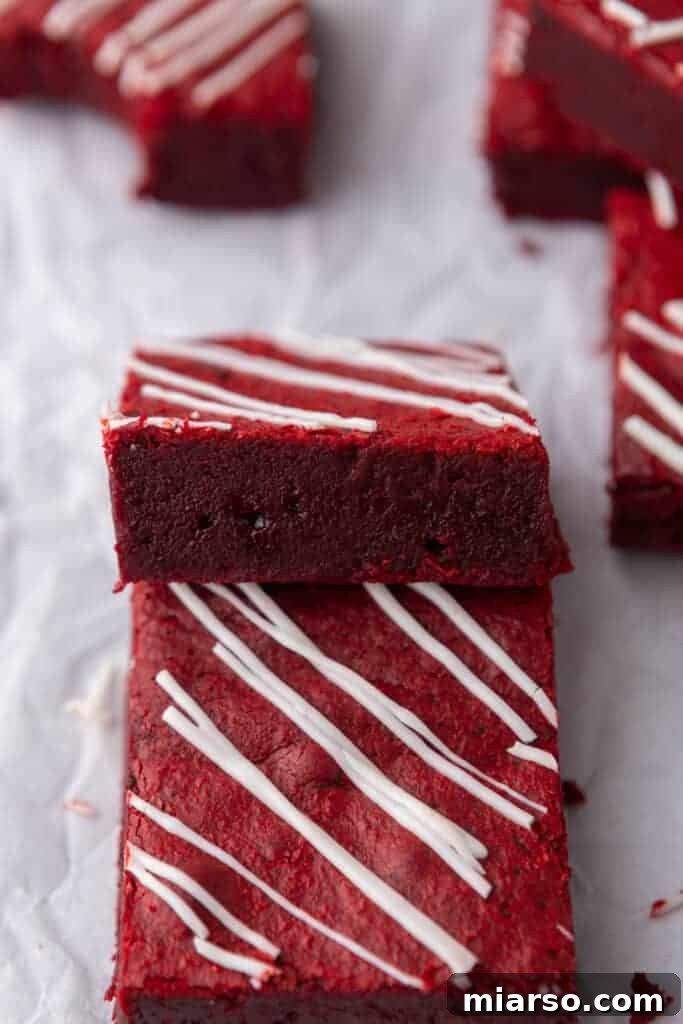 Stack of freshly baked fudgy red velvet brownies, ready for serving or storage.