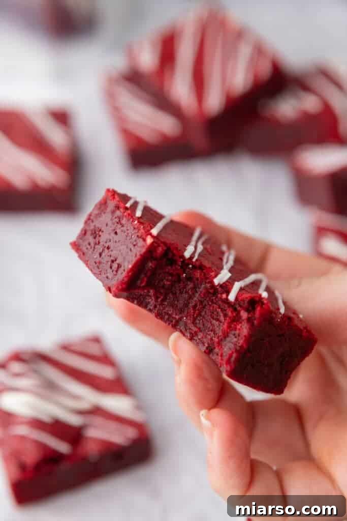 A delicious red velvet brownie with a bite taken out, revealing its fudgy, moist interior.