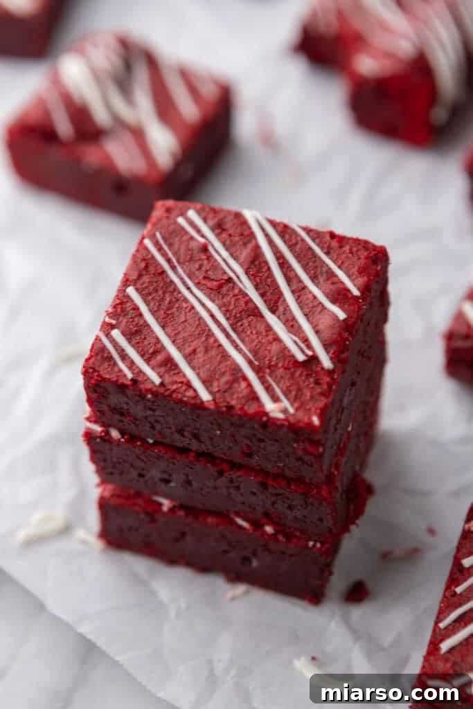 A stunning stack of Fudgy Red Velvet Brownies, showcasing their decadent texture and appealing crimson color.