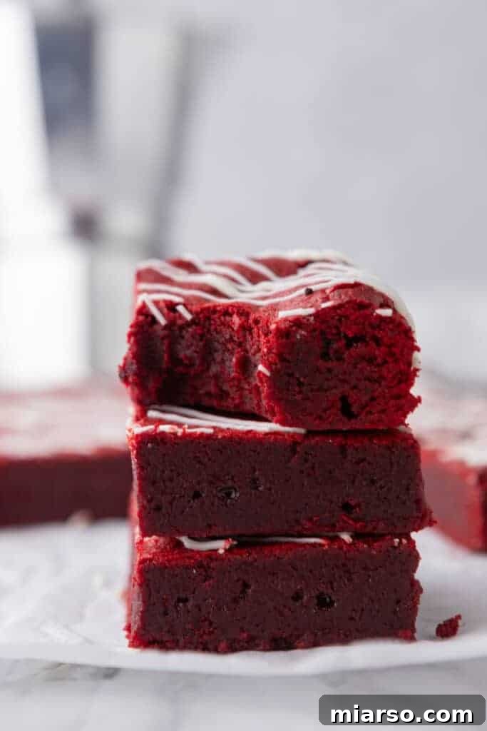 A delectable stack of fudgy red velvet brownies, showcasing their vibrant color and moist texture.