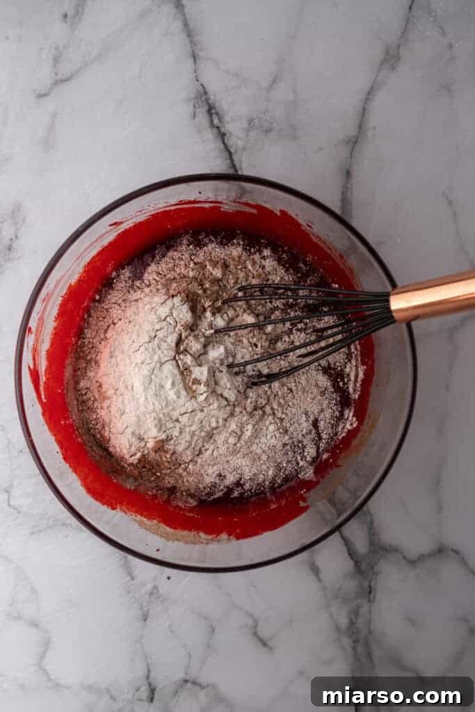 The smooth, ruby-red red velvet brownie batter in a bowl, ready for the dry ingredients.