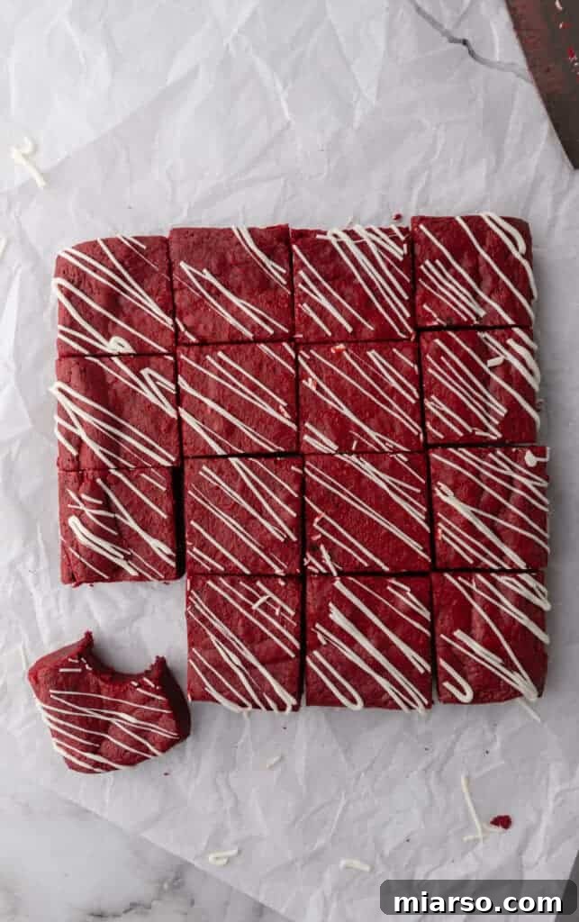 Freshly baked fudgy red velvet brownies cooling in the pan, displaying a perfect crinkly top.