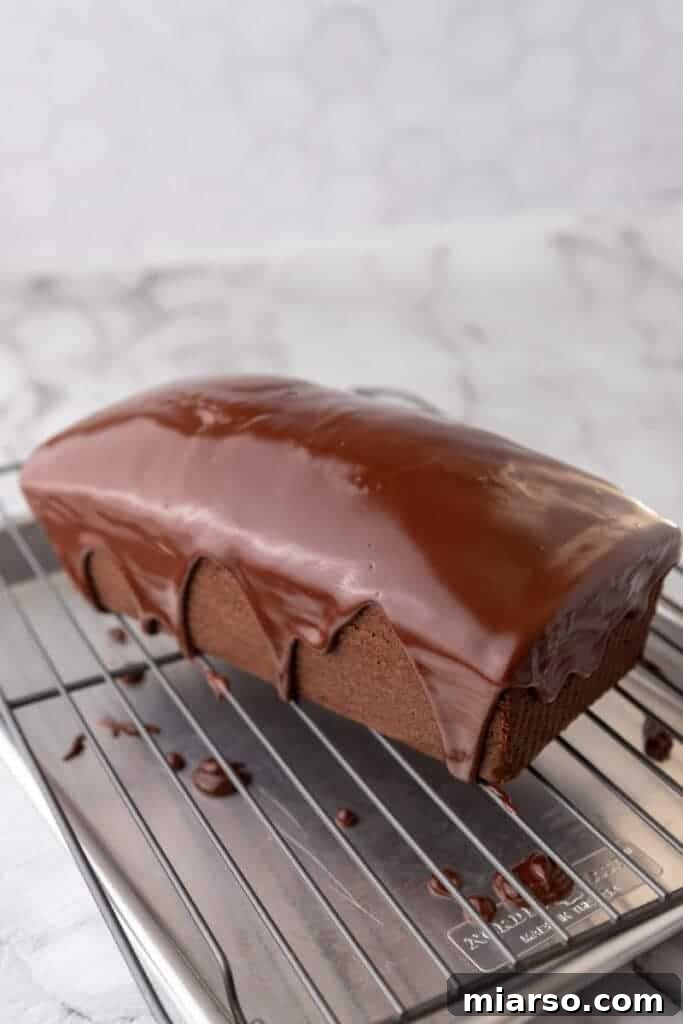 Ultimate Decadent Chocolate Pound Cake Recipe 13 A side view of the freshly baked chocolate pound cake loaf cooling on a wire rack.