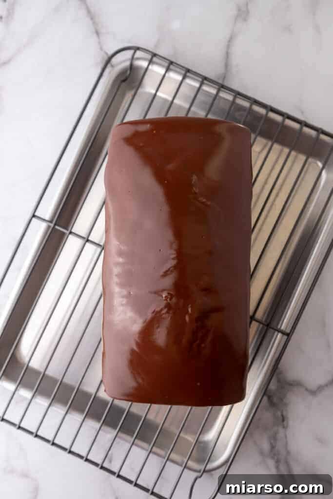 Ultimate Decadent Chocolate Pound Cake Recipe 10 A fully prepared chocolate pound cake with ganache, resting on a wire rack.