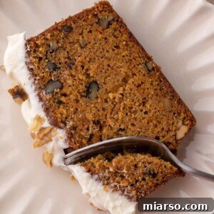 a slice of the carrot cake loaf cake recipe getting a piece taken out