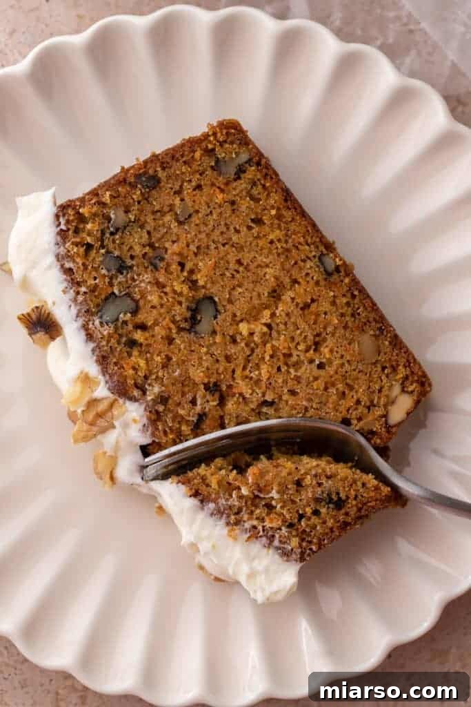 a slice of the carrot cake loaf cake recipe getting a piece taken out