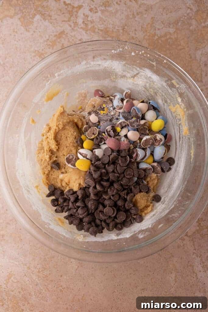 Gooey Giant Cadbury Mini Egg Skillet Cookie 7 Cadbury mini eggs and chocolate chips being added to the cookie dough.