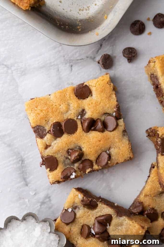 Nestle Toll House Cookie Bars Recipe - A sheet pan filled with golden brown, chocolate chip-studded cookie bars, freshly baked and ready to be sliced, showcasing their warm, inviting texture.