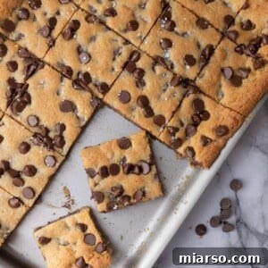 A beautifully presented, perfectly portioned Nestle Toll House Chocolate Chip Cookie Bar, rich with visible melted chocolate and a tempting golden-brown edge, ready to be enjoyed.