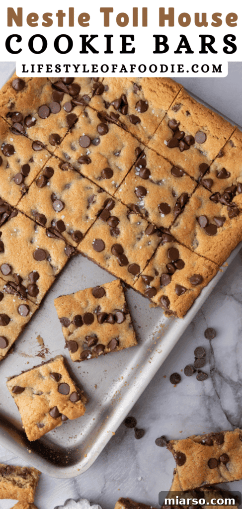 A close-up of a single Nestle Toll House Cookie Bar, showcasing its delightful chewiness and abundant, perfectly melted chocolate chips, ready to be picked up.