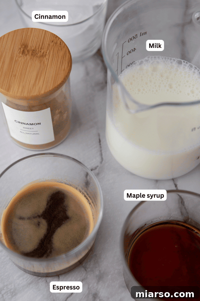A rustic display of ingredients for maple latte: a jug of milk, a bottle of maple syrup, coffee beans, and cinnamon sticks.