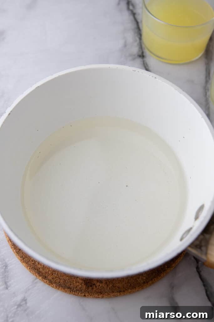 Water and sugar being combined in a small pot for simple syrup