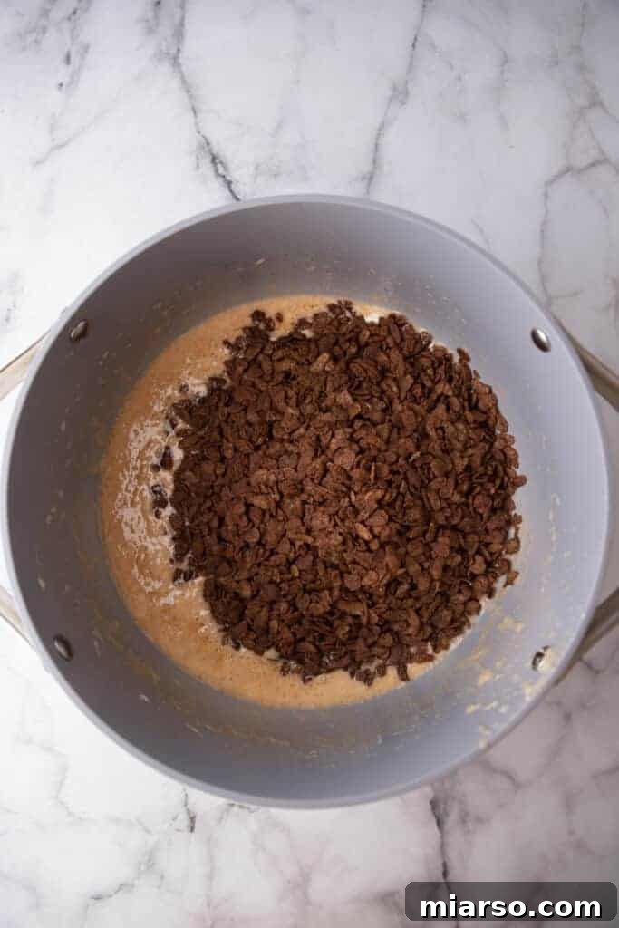 Ultimate Chocolate Rice Krispies Treats 6 cereal on top of marshmallows in a pot