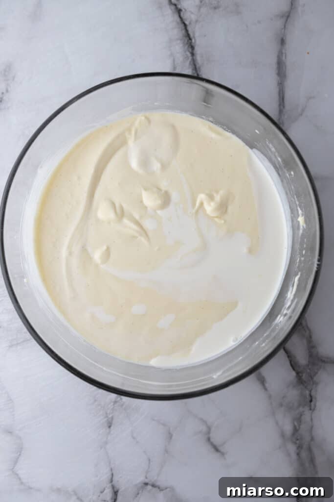 Raw cheesecake batter in a mixing bowl, smooth and creamy