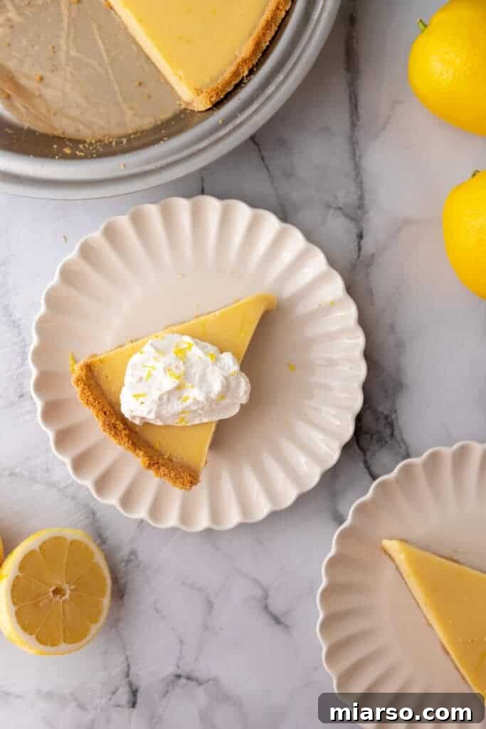 Several slices of lemon pie with graham cracker crust and whipped cream, arranged beautifully on individual plates