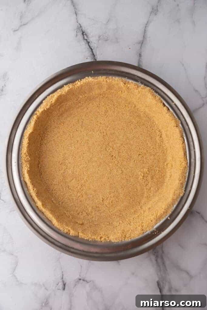 A perfectly baked graham cracker crust, golden brown and firm, cooling in a pie pan