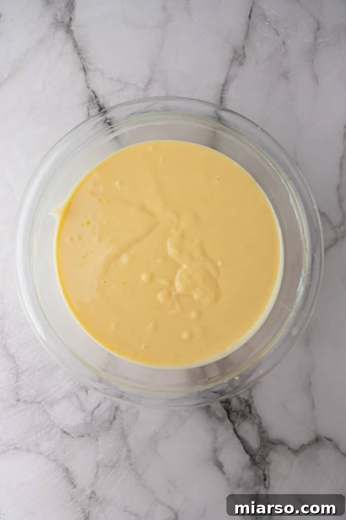 The lemon pie filling ingredients fully mixed and smooth in a large bowl, ready to be poured