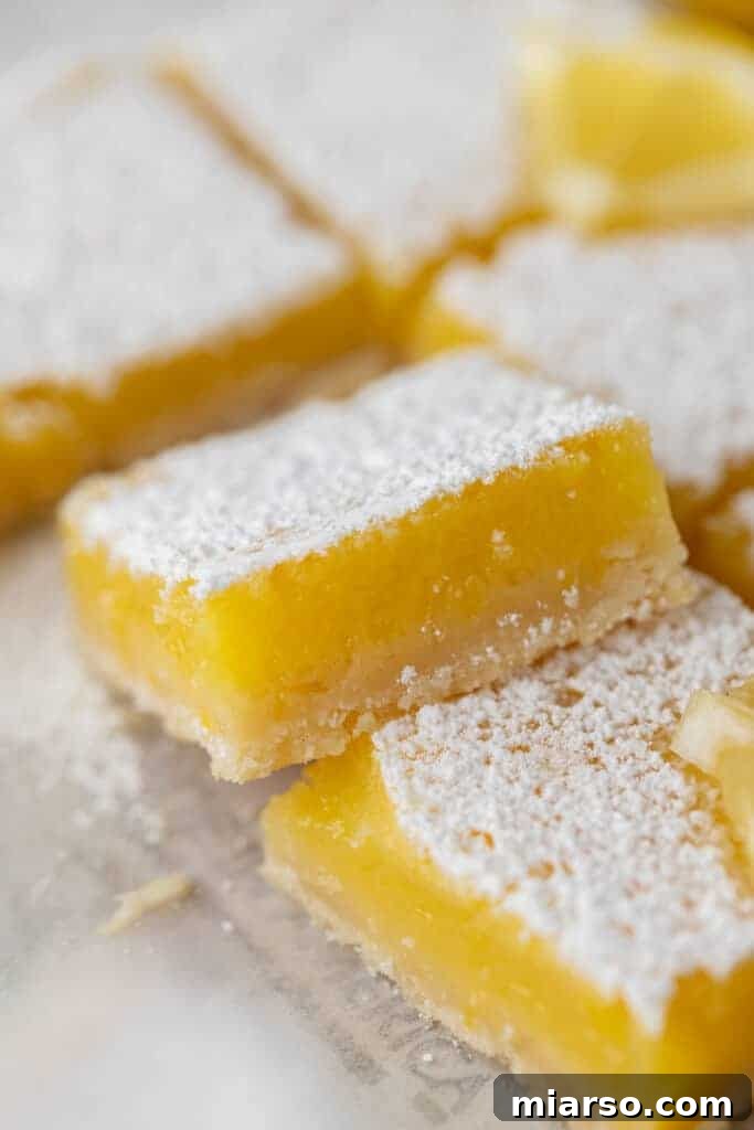 Close-up of a square of the easy lemon bars recipe, showcasing the golden crust and bright yellow filling.