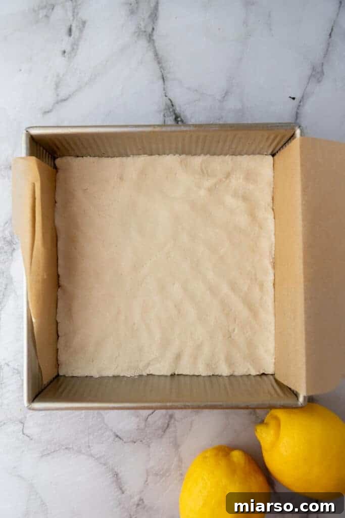 Pressed shortbread crust in a baking pan, ready for the oven.