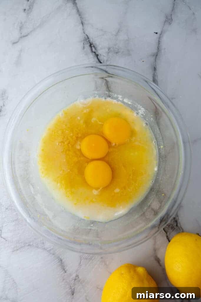 Unmixed filling ingredients in a bowl: eggs, sugar, lemon juice, and zest.