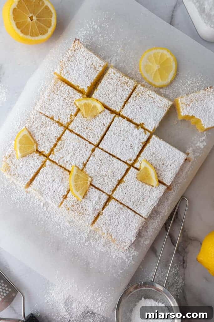 Fully baked easy lemon bars recipe cut into squares, dusted with powdered sugar.