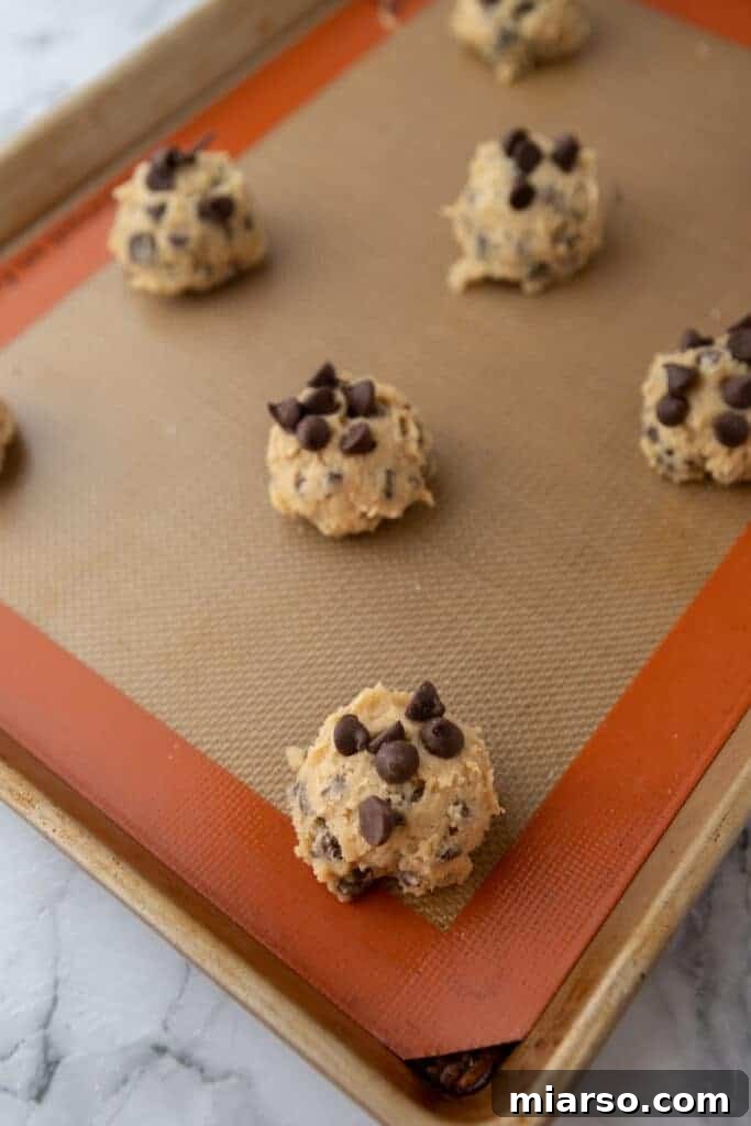 dough balls on a silicone mat on a baking sheet