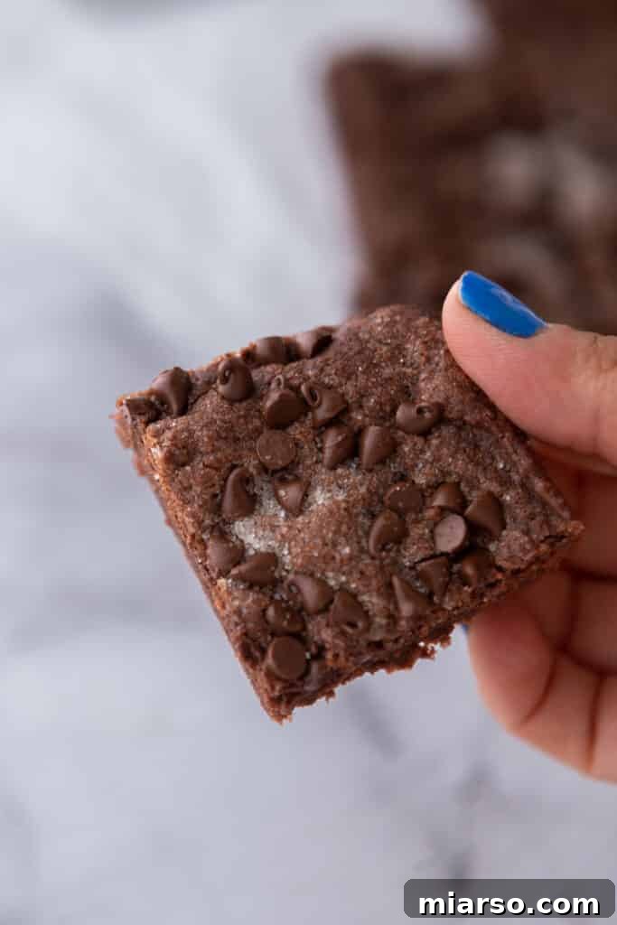 close up of the chocolate sugar cookie bars recipe being held up by a hand