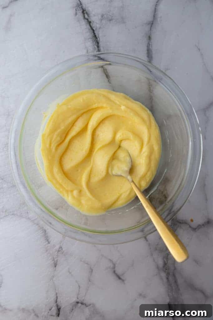 Microwave Magic: Luscious Lemon Curd in Minutes 10 Chilled microwave lemon curd being stirred gently with a spoon, showing its creamy consistency.