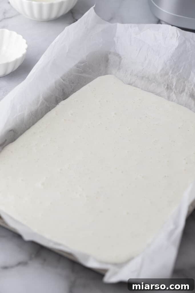 The cottage cheese wrap mixture spread thinly and evenly on a parchment-lined baking pan, pre-baking.