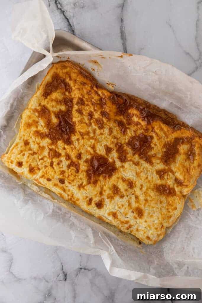 The baked cottage cheese wrap, lightly golden and set, still on the baking pan, ready to be removed and filled.