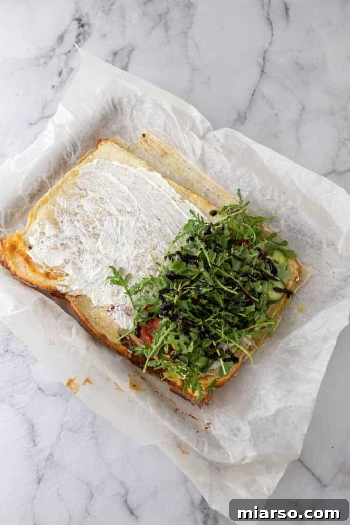 A baked cottage cheese wrap on a pan, topped with fresh arugula and other colorful fillings, demonstrating its versatility.