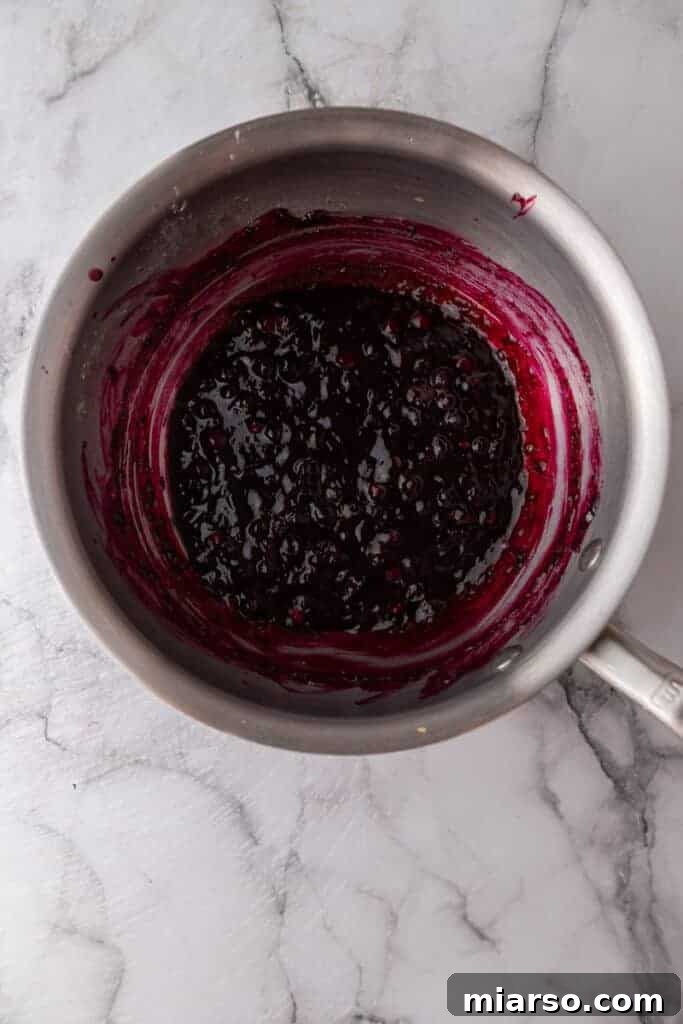 Mixed blueberry topping ingredients simmering in a pot