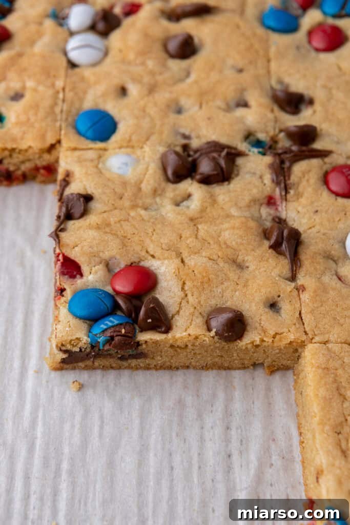 Sliced patriotic sheet pan red white and blue M&M's cookie bars arranged for serving.