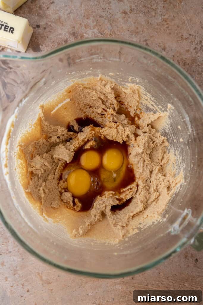 Butter, sugar, and eggs being mixed in a bowl, showing the combined wet ingredients.
