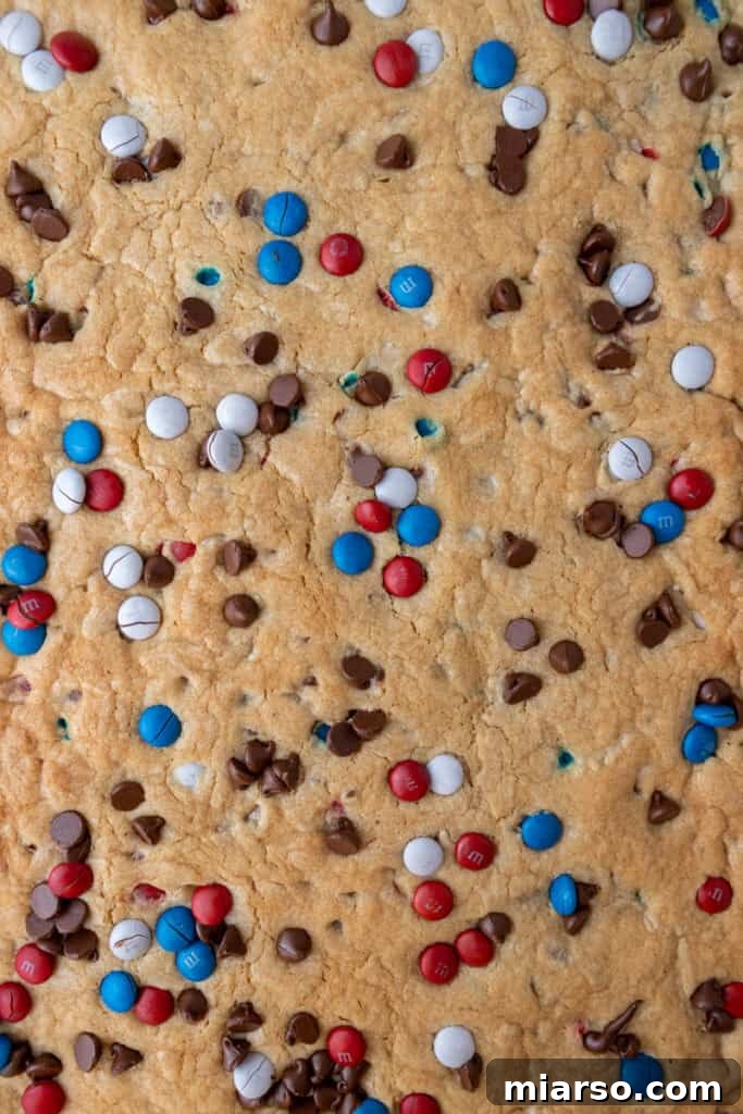 Close-up of freshly baked patriotic sheet pan red white and blue M&M's cookie bars, showcasing a golden crust.