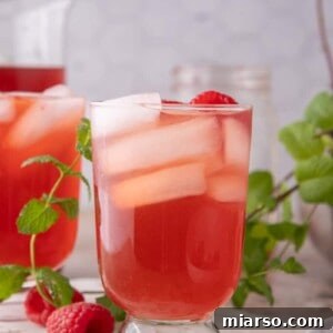 Raspberry Iced Tea recipe in a glass with ice and fresh berries