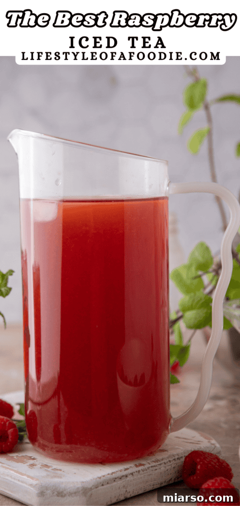 Pinterest pin image for the Raspberry Iced Tea Recipe, showing a pitcher of tea