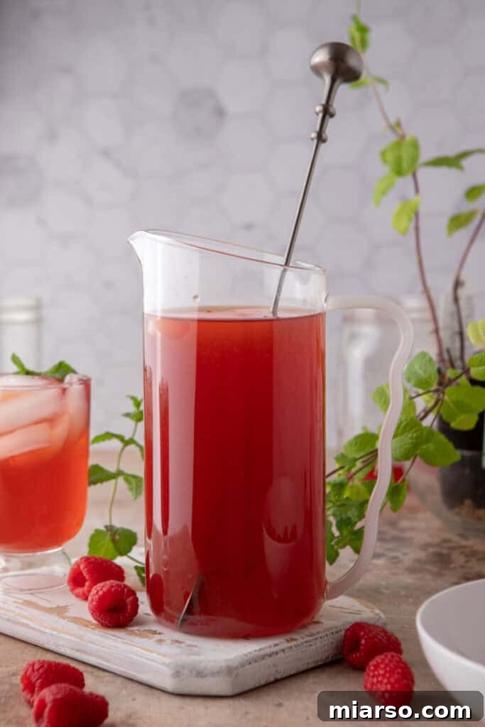 Side shot of the raspberry iced tea recipe in a pitcher, ready to serve