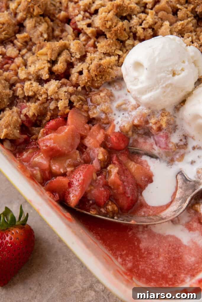 Your New Favorite Strawberry Rhubarb Crisp 2 Delicious Strawberry Rhubarb Crisp served warm in a dish with a scoop of melting vanilla ice cream.