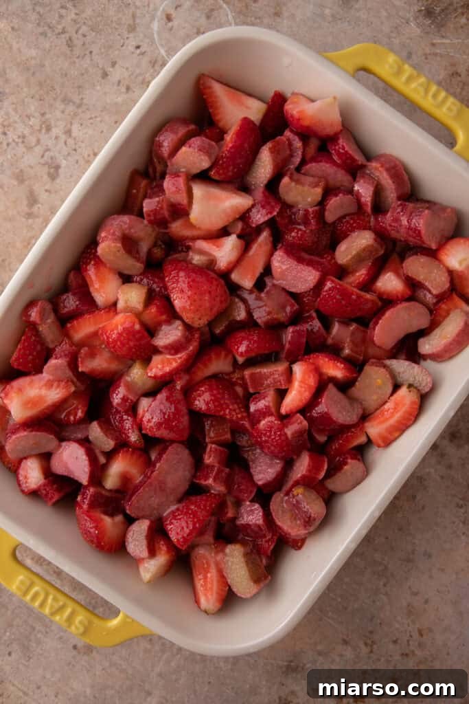Your New Favorite Strawberry Rhubarb Crisp 9 Mixed strawberry and rhubarb fruit filling in a baking dish.