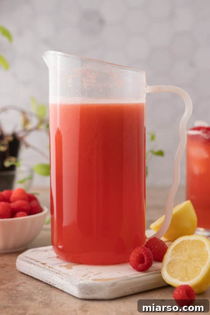 A large pitcher full of homemade raspberry lemonade