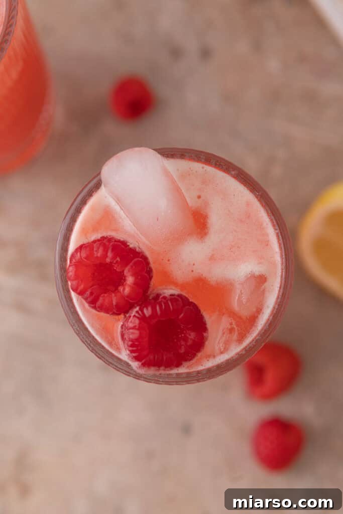 Close-up overhead shot of raspberry lemonade with lemon slices and berries