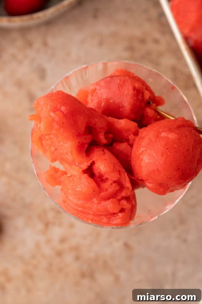 Overhead shot of two glasses filled with vibrant strawberry sorbet, ready to be enjoyed.